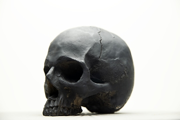 Image showing Spooky dark black skull aginast white background isolated