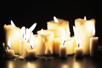 Image showing Candles glowing against dark background