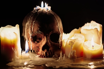 Image showing Human skull against dark background in candle light closeup