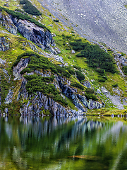Image showing Mountain slope with small lake at botom