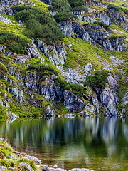 Image showing Mountain slope with small lake at botom