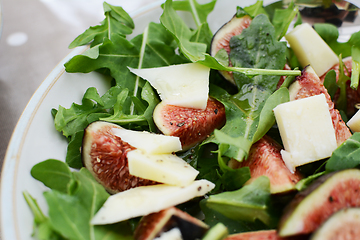 Image showing Fresh fig and pecorino chunks on a bed of green rocket leaves