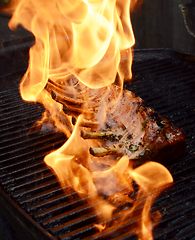 Image showing Hot flames engulf grilled rack of lamb 