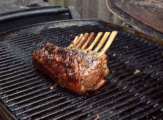 Image showing Juicy rack of lamb grilling on a summer barbecue