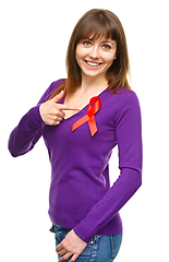 Image showing Woman is pointing to the red awareness ribbon