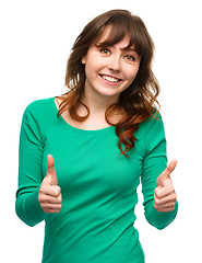 Image showing Woman is showing thumb up gesture