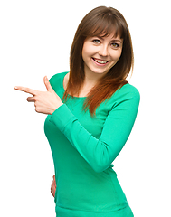 Image showing Portrait of a young woman pointing to the left