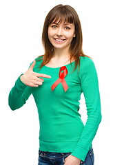Image showing Woman is pointing to the red awareness ribbon