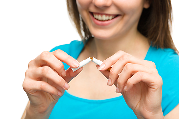 Image showing Young woman is breaking a cigarette