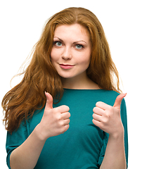 Image showing Woman is showing thumb up gesture