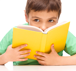 Image showing Little boy plays with book