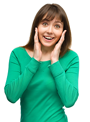 Image showing Woman is holding her face in astonishment