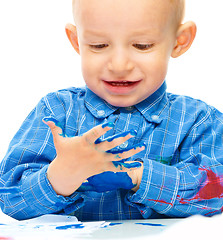 Image showing Little boy is playing with paints