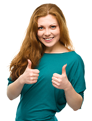 Image showing Woman is showing thumb up gesture