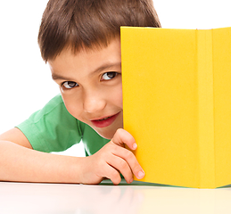 Image showing Little boy plays with book