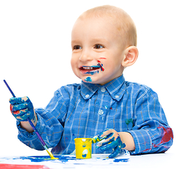 Image showing Little boy is playing with paints