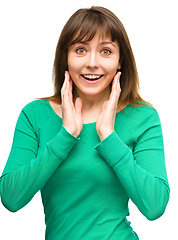 Image showing Woman is holding her face in astonishment