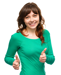 Image showing Woman is showing thumb up gesture