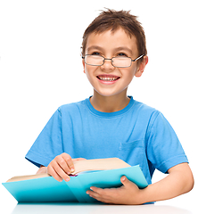 Image showing Little boy is reading a book