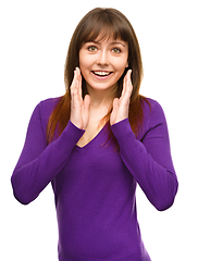 Image showing Woman is holding her face in astonishment