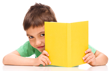 Image showing Little boy plays with book