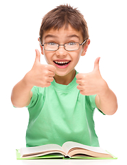 Image showing Little boy is reading a book