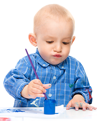 Image showing Little boy is playing with paints