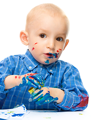 Image showing Little boy is playing with paints