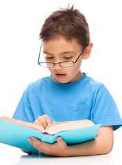 Image showing Little boy is reading a book