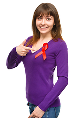 Image showing Woman is pointing to the red awareness ribbon