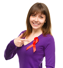 Image showing Woman is pointing to the red awareness ribbon