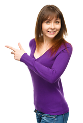 Image showing Portrait of a young woman pointing to the left