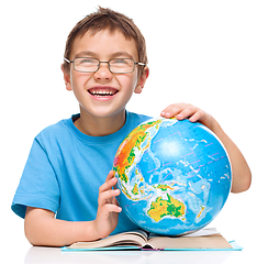 Image showing Little boy is examining globe