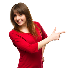 Image showing Portrait of a young woman pointing to the right