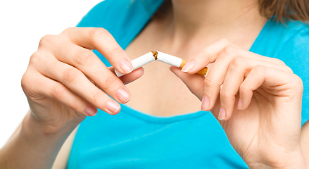 Image showing Young woman is breaking a cigarette