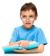 Image showing Little boy is reading a book