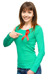 Image showing Woman is pointing to the red awareness ribbon