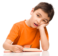 Image showing Little boy is tired to read his book