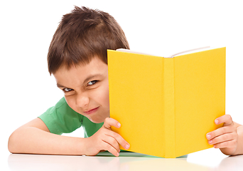 Image showing Little boy plays with book