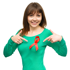 Image showing Woman is pointing to the red awareness ribbon