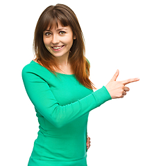 Image showing Portrait of a young woman pointing to the right