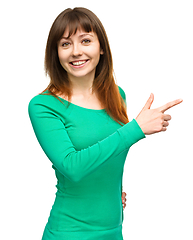 Image showing Portrait of a young woman pointing to the right