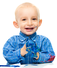 Image showing Little boy is playing with paints