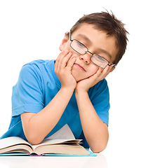 Image showing Little boy is tired to read his book