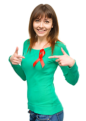 Image showing Woman is pointing to the red awareness ribbon