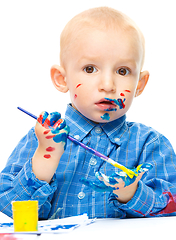 Image showing Little boy is playing with paints