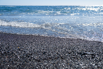 Image showing ocean water on black sand