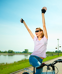 Image showing Young woman is sitting on her bicycle