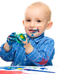 Image showing Little boy is playing with paints