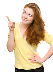 Image showing Portrait of a young woman pointing to the right